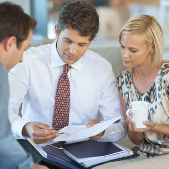 Financial advisor talking to couple on sofa