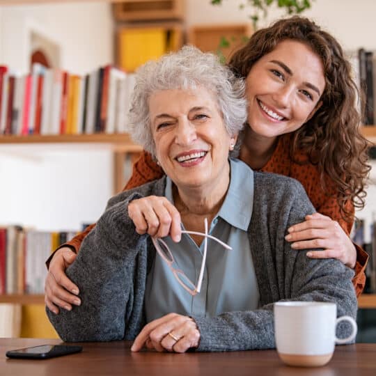 Happy granddaughter embracing senior grandmother