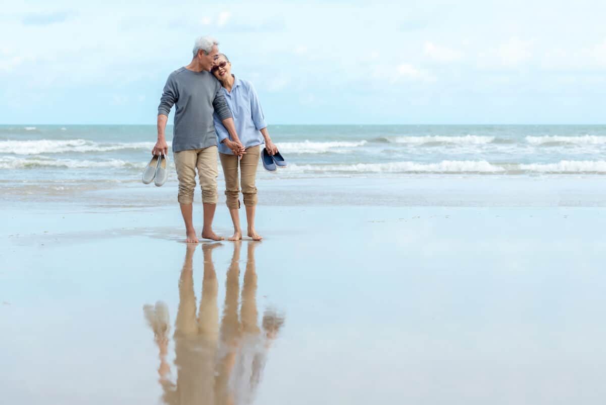 Lifestyle asian senior couple happy walking hug and relax on the beach. Tourism elderly family travel leisure and activity after retirement in vacations and summer.