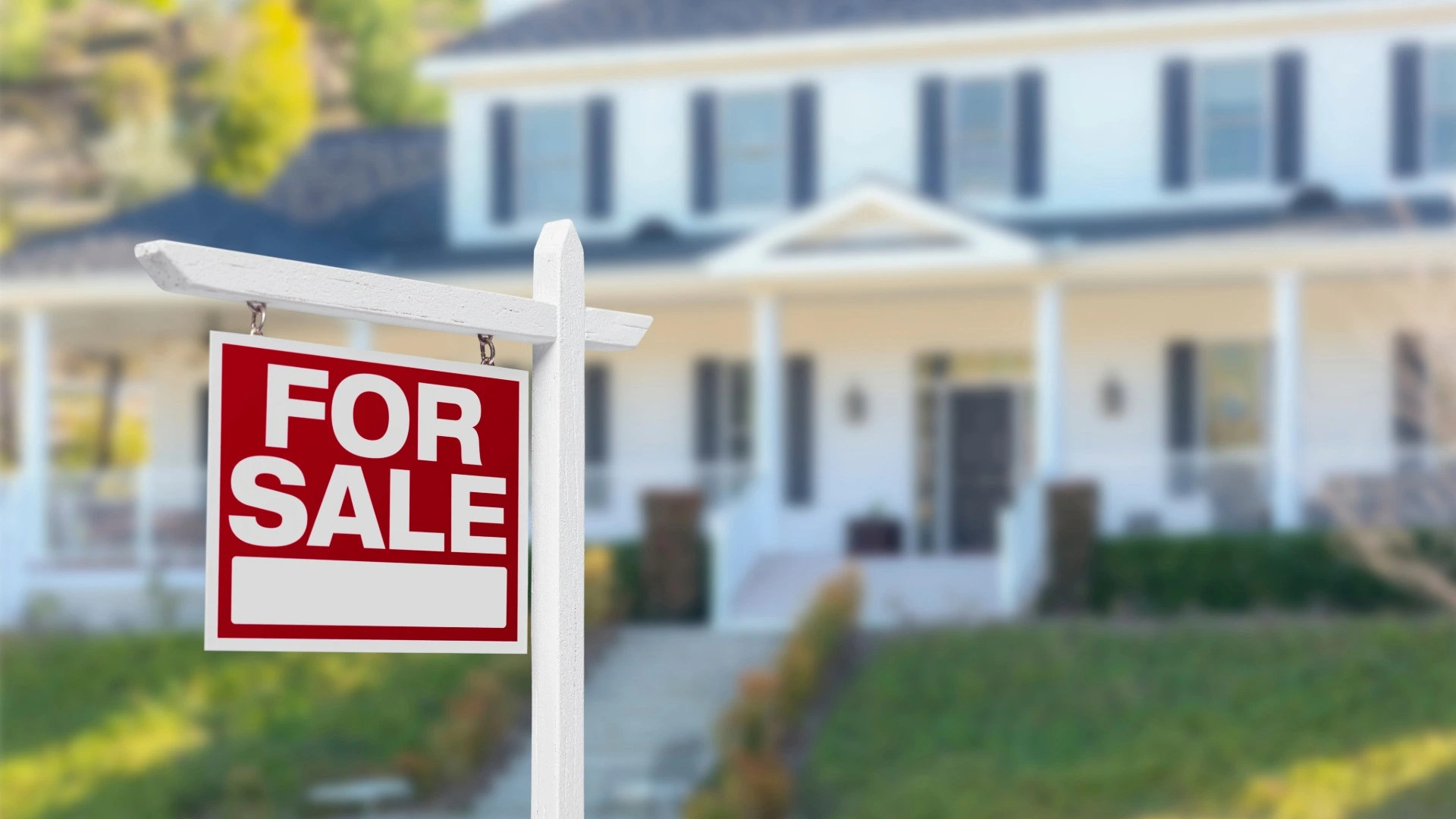 Red and white For Sale sign in front of house